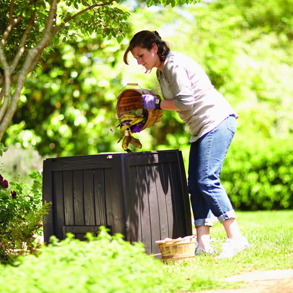 Emptying kitchen scraps into a garden composter